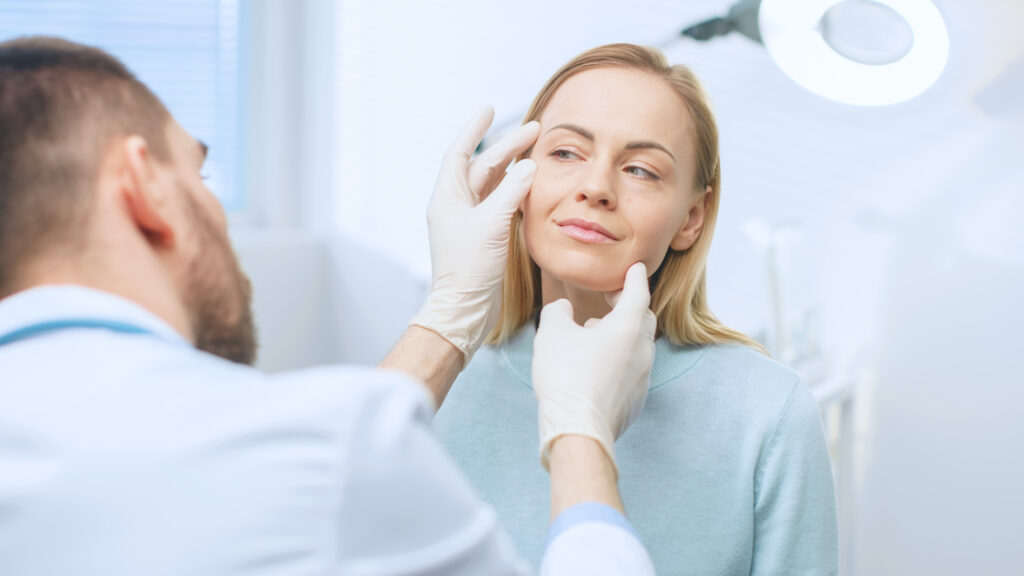 Plastic / Cosmetic Surgeon Examines Beautiful Woman's Face, Touc